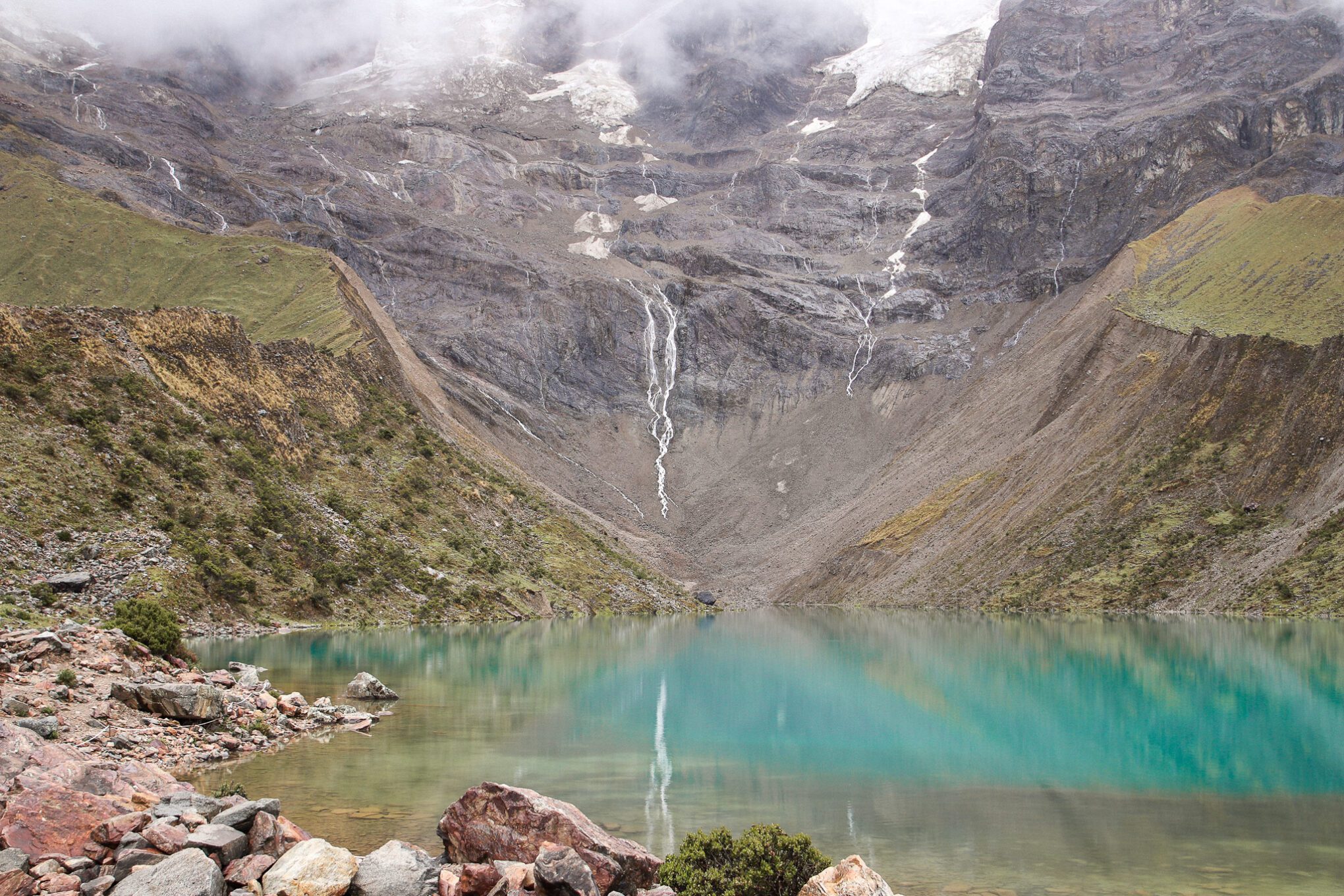 Humantay lake with mountain in the background with some ice at the top melting