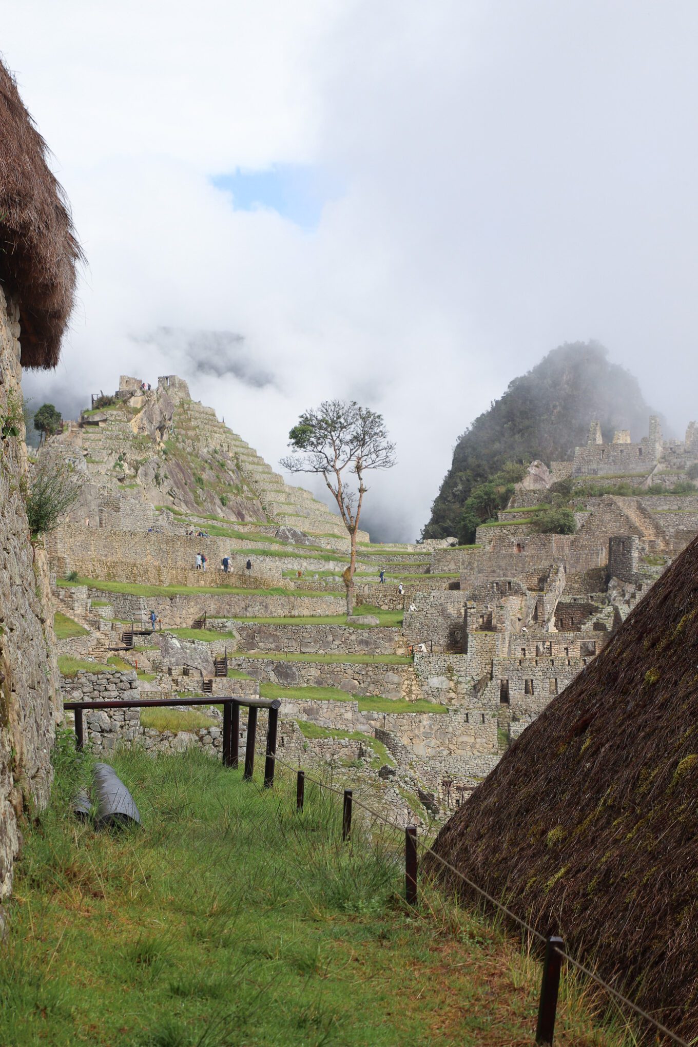 Machu Picchu ruins with Huayna Picchu in the background surrounded by clouds