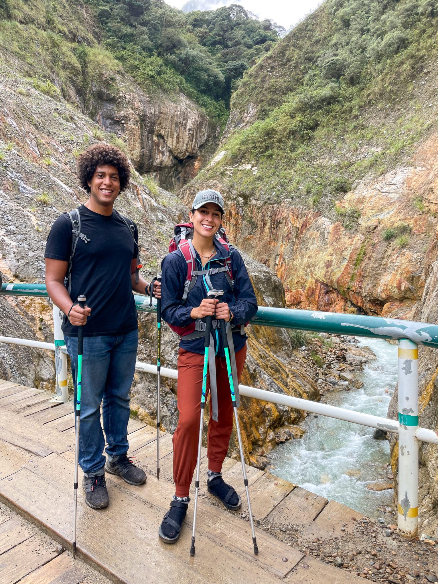 Thais and Kelvyn crossing a bridge on top of a waterfall