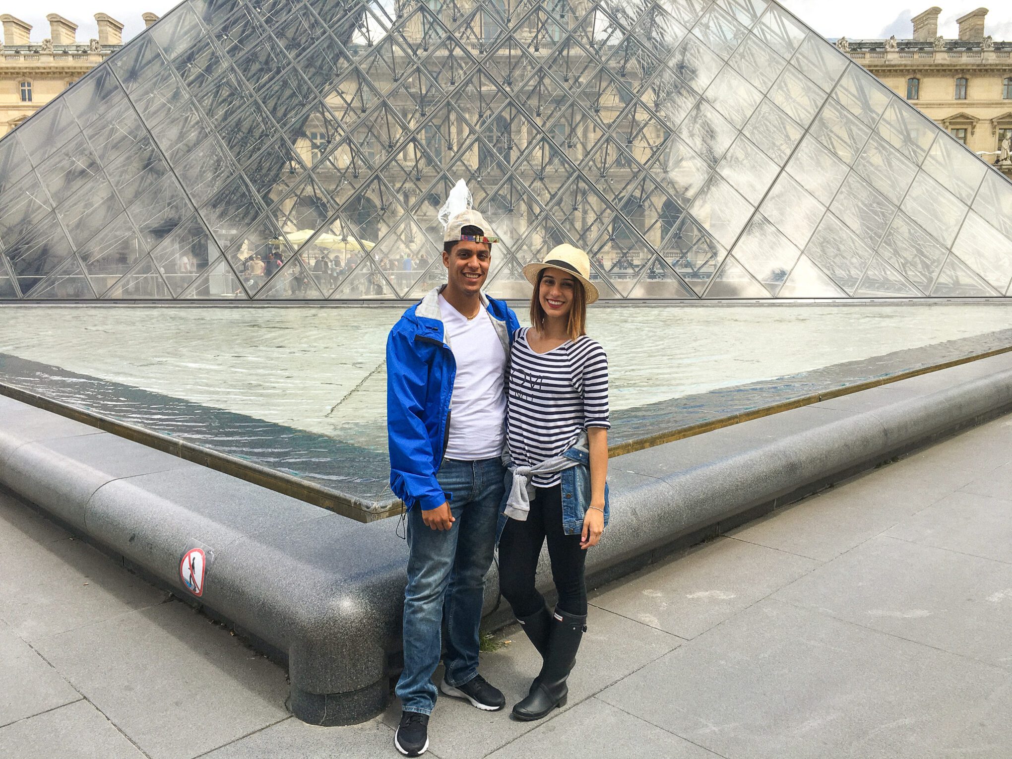 The Louvre Pyramid in Paris 2016. Thais and Kelvyn standing in front posing on their first international trip to Europe.