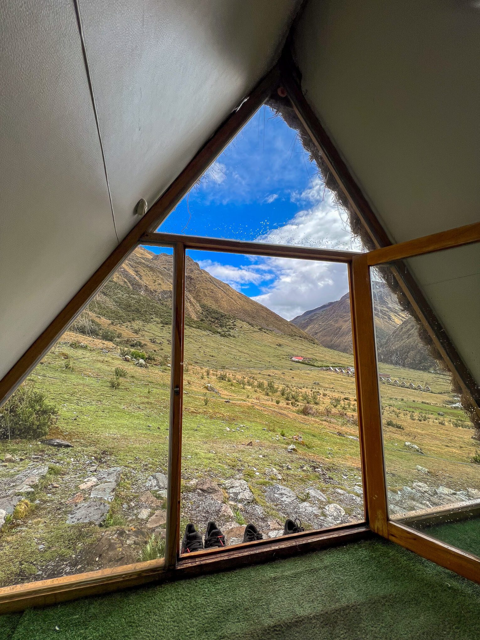 View of mountains from inside hut with glass window