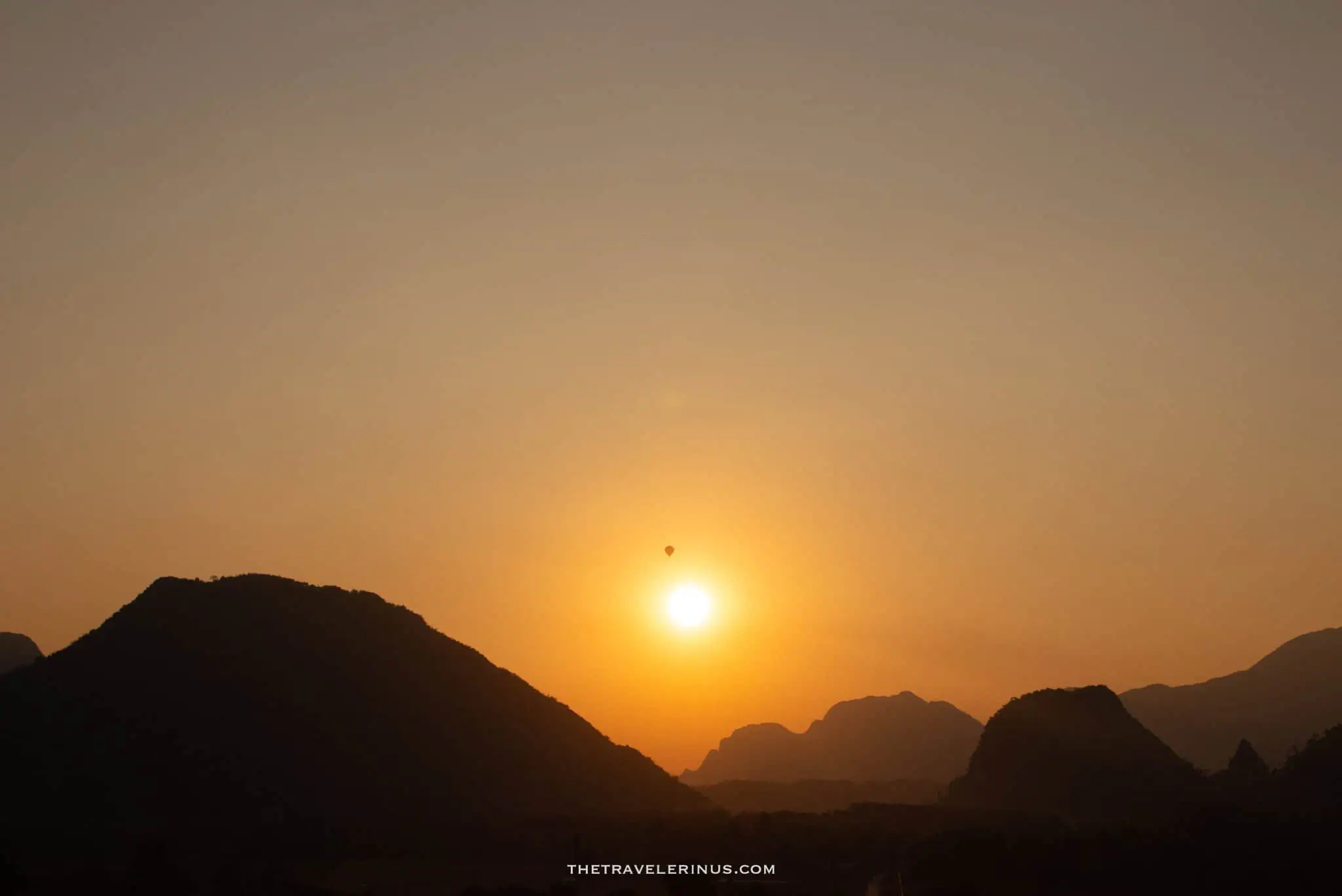 hot air balloon flying through mountains during sunset, Vang Vienna Laos