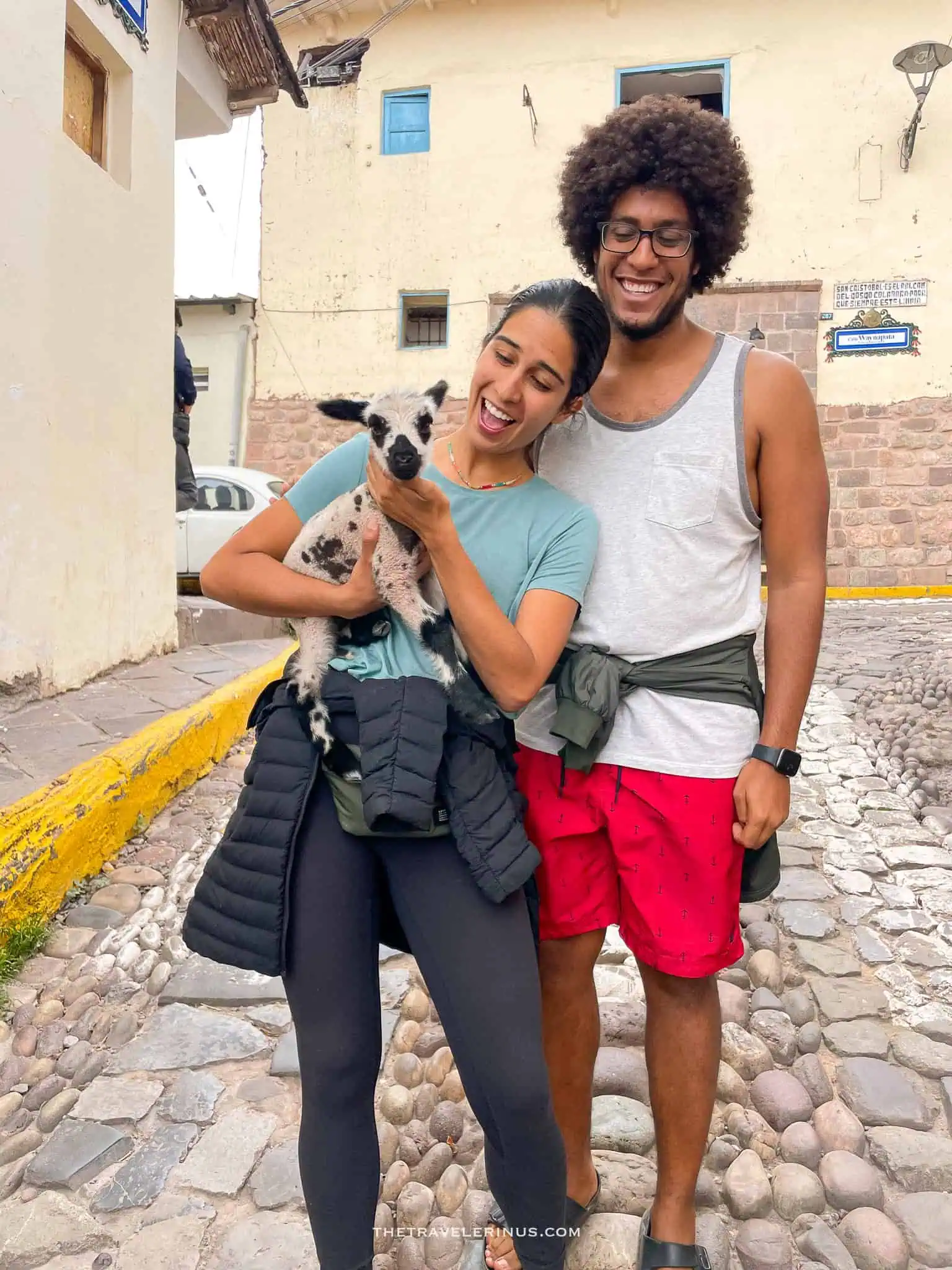 thais and kelvyn holding a baby llama cusco peru